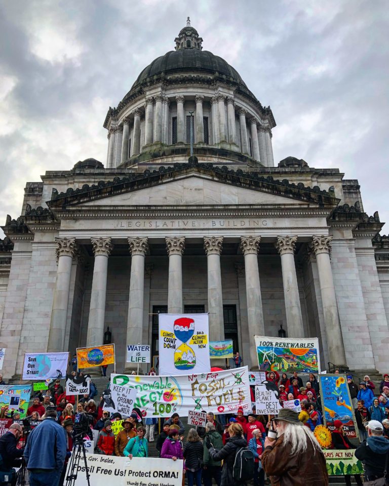 Renewable energy activists gather in front of state capitol building in Olympia, Washington
