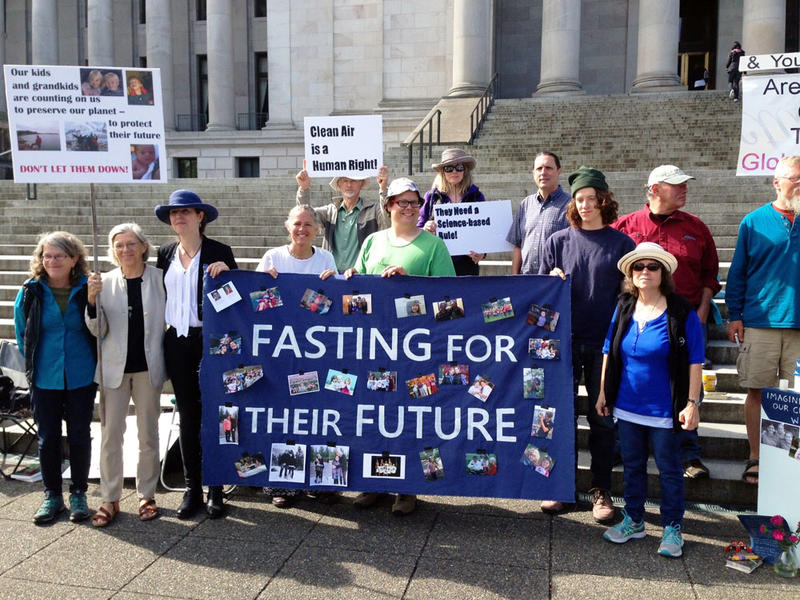 Climate activists at state capitol in Olympia Washington hold banner that reads "Fasting for their Future"