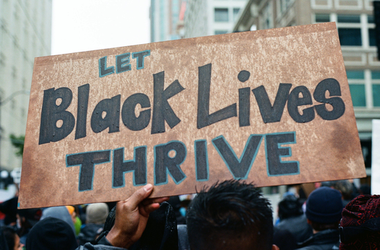 Sign held aloft a march in Seattle with message "Let Black Lives Thrive"