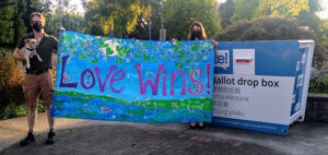 350 Seattle activists hold "Love Wins!" banner in front of ballot drop box