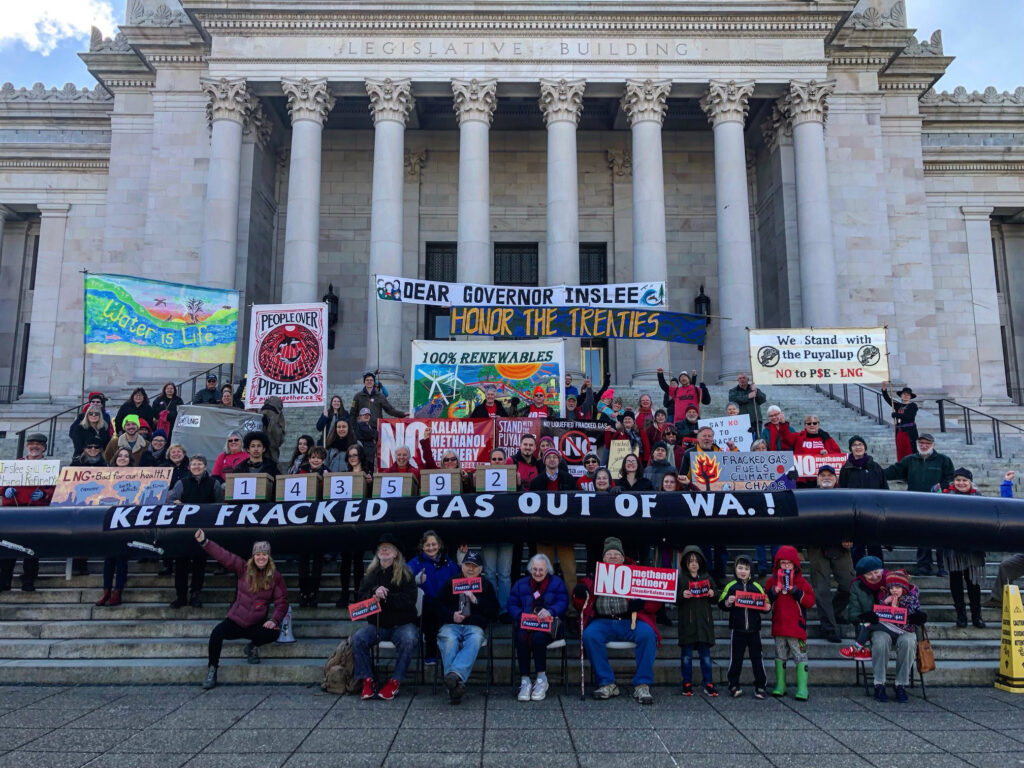 "People over Pipelines" advocates hold banners in front of Olympia capitol building