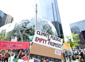 sign reading climate pledge = empty promises in front of the amazon spheres